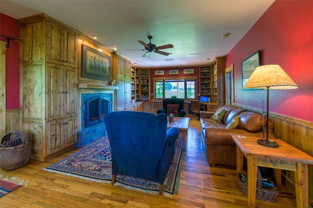 living room with built in features, ceiling fan, and dark hardwood / wood-style floors