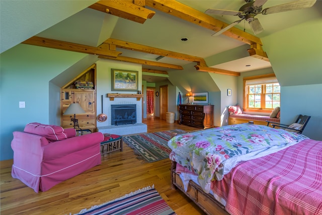 bedroom featuring ceiling fan, vaulted ceiling with beams, and hardwood / wood-style flooring