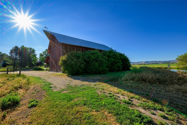 view of yard featuring a rural view and an outbuilding