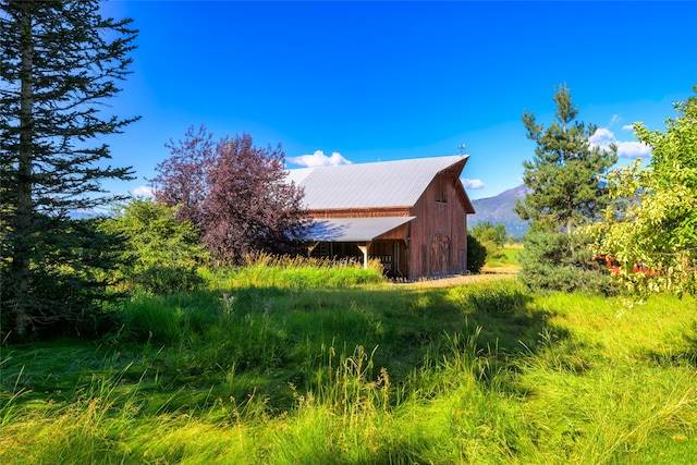 view of property exterior with a mountain view and an outbuilding