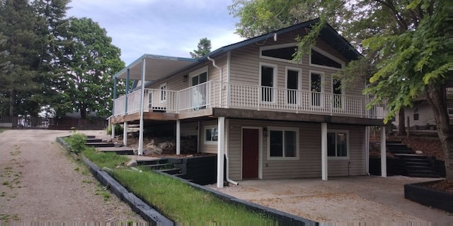 view of property exterior featuring a deck and stairway