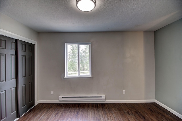 unfurnished bedroom featuring dark wood-type flooring, baseboard heating, and baseboards