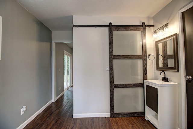 bathroom with baseboards, wood finished floors, and vanity