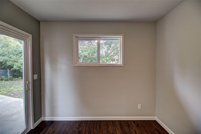 unfurnished room with baseboards and dark wood-style flooring