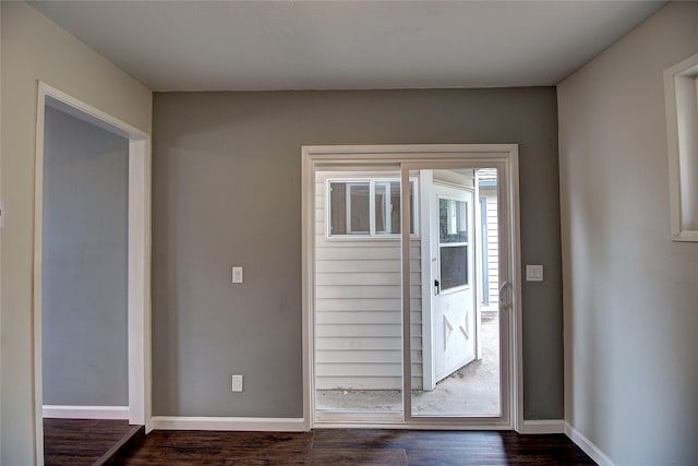 doorway featuring dark wood finished floors and baseboards