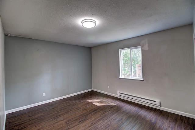 empty room with a baseboard heating unit, dark wood-style flooring, a textured ceiling, and baseboards