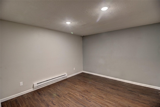 empty room featuring baseboards, a textured ceiling, a baseboard heating unit, and dark wood-type flooring