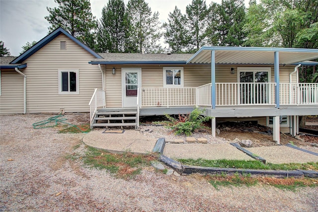 back of house with a porch and a shingled roof