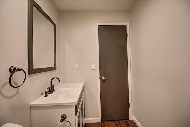 bathroom featuring baseboards, wood finished floors, and vanity