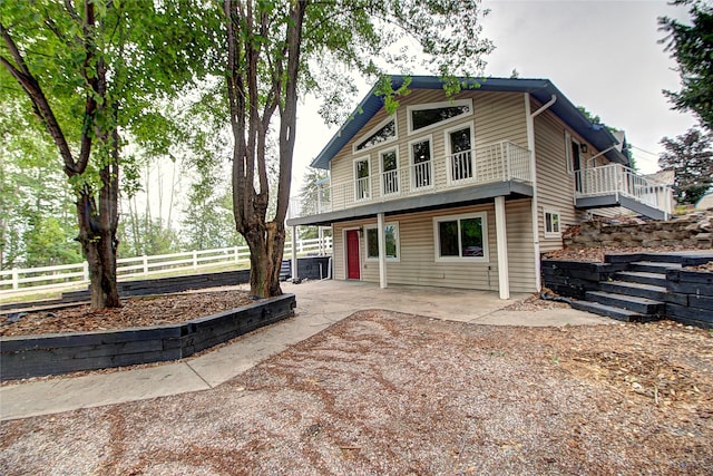 view of front of house with a patio and fence