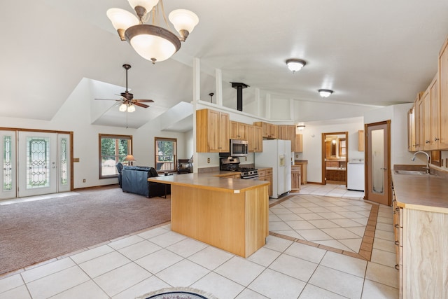 kitchen featuring light tile patterned flooring, kitchen peninsula, ceiling fan, stainless steel appliances, and sink