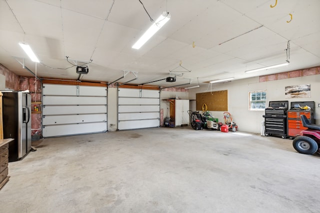 garage featuring a garage door opener and stainless steel refrigerator with ice dispenser