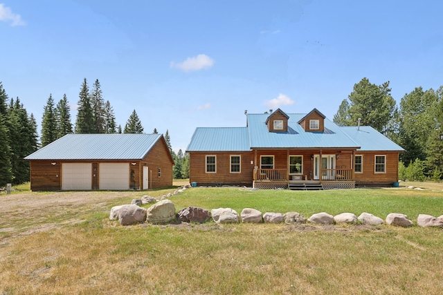 view of front facade featuring covered porch, a garage, an outbuilding, and a front yard