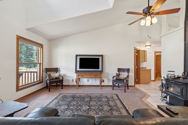 living room with light colored carpet, ceiling fan, high vaulted ceiling, and a wood stove