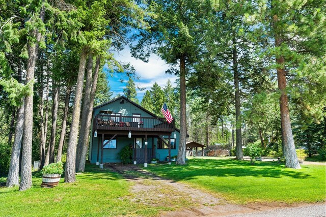 159 Sylvan Dr, Bigfork, MT 59911 - view of front facade with a wooden deck and a front yard