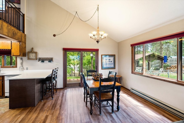 159 Sylvan Dr, Bigfork, MT 59911 - dining space with a baseboard radiator, healthy amount of natural light, wood finished floors, a chandelier, and high vaulted ceiling