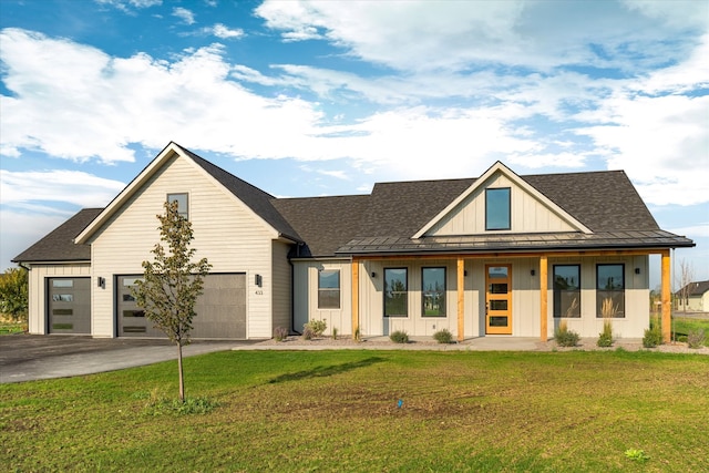 view of front of house featuring a garage, a front yard, and covered porch