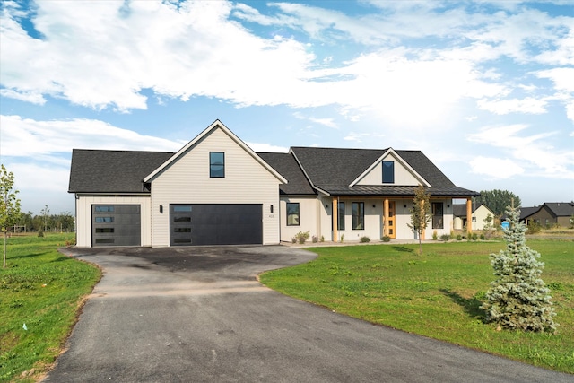 modern farmhouse featuring a front yard and a garage