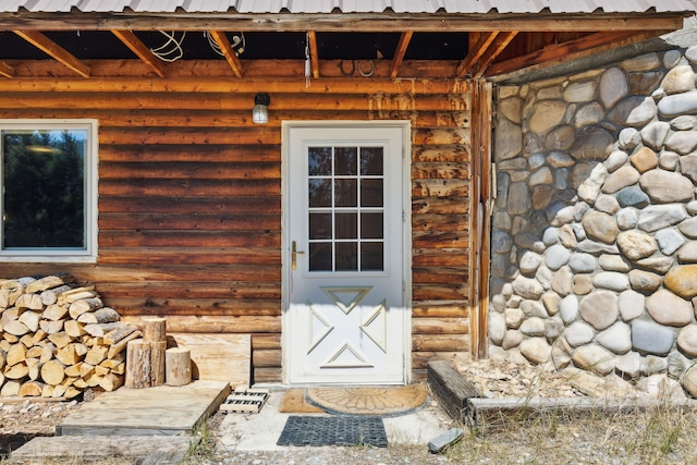 property entrance featuring log siding and metal roof