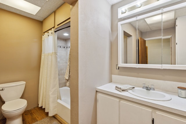 full bath featuring shower / bath combo, wood finished floors, toilet, and vanity