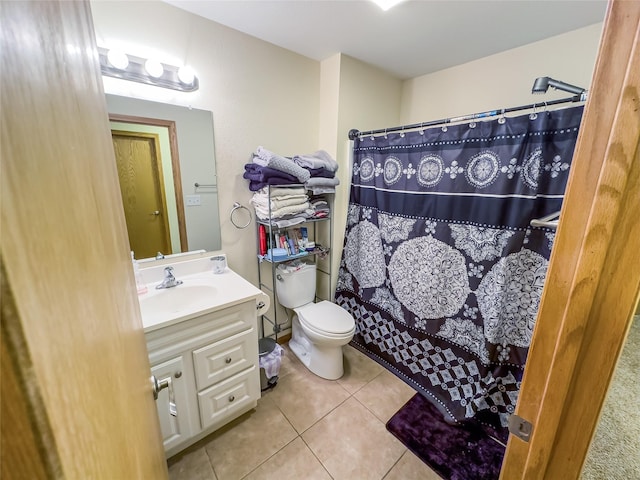 bathroom with vanity, tile patterned floors, toilet, and walk in shower