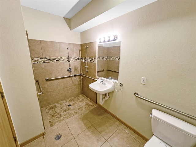 bathroom with sink, a tile shower, tile patterned floors, and toilet