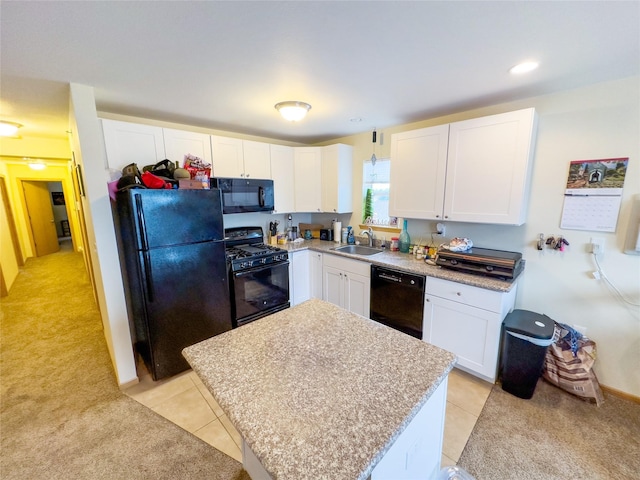 kitchen with light tile patterned flooring, sink, black appliances, a kitchen island, and white cabinets