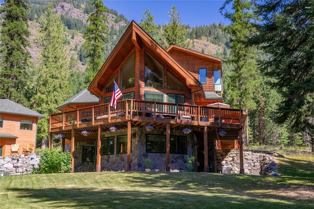 rear view of house with a deck, cooling unit, and a lawn