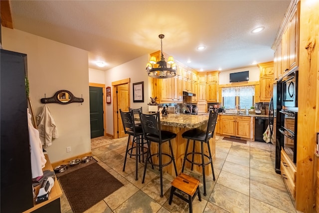 kitchen with tasteful backsplash, black appliances, light brown cabinets, light tile patterned floors, and a breakfast bar area