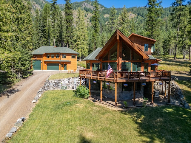 back of house with a lawn, a deck, and a garage