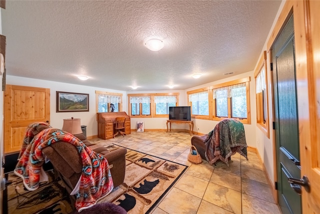 living room featuring a textured ceiling and light tile patterned floors