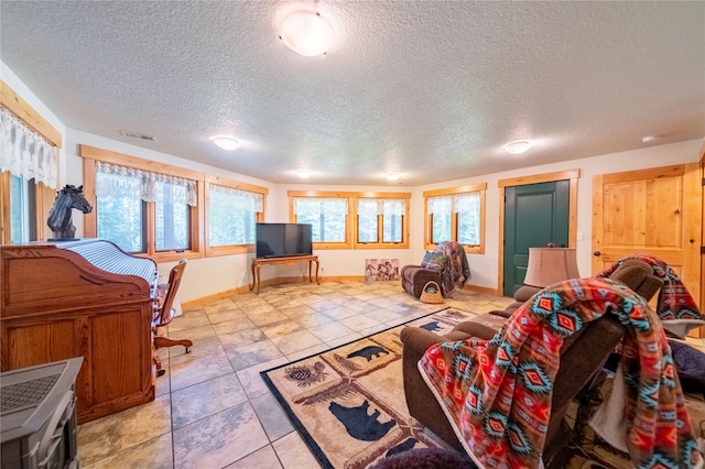 living room featuring a textured ceiling and light tile patterned floors