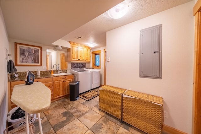 kitchen with sink, a textured ceiling, electric panel, light tile patterned floors, and independent washer and dryer