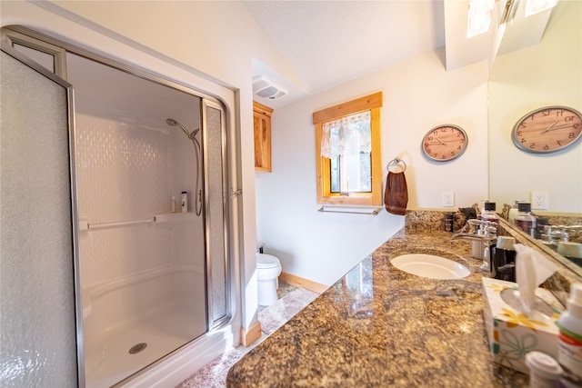 bathroom featuring toilet, a textured ceiling, a shower with shower door, and vanity