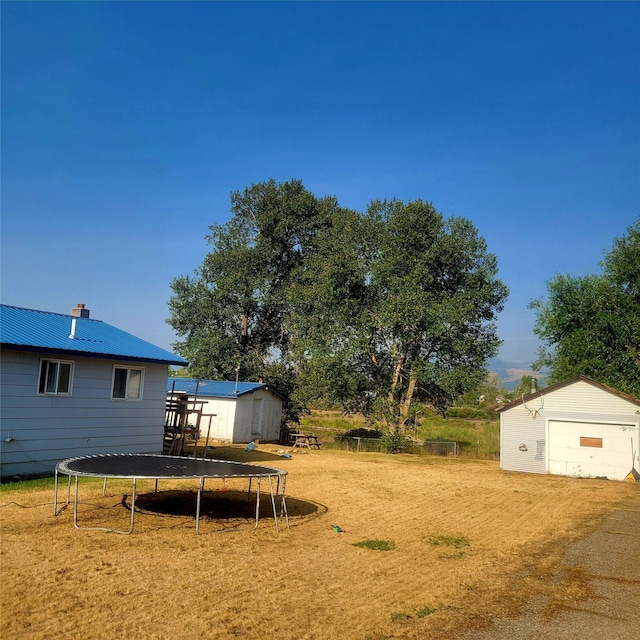 view of yard with an outbuilding and a trampoline