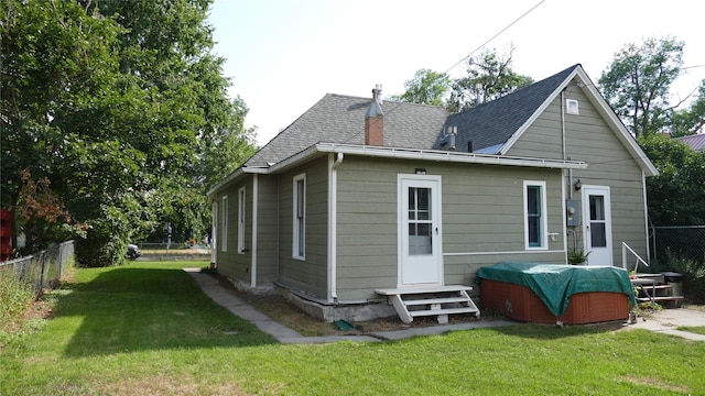 rear view of house featuring a yard