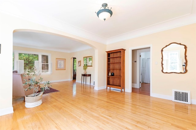 empty room featuring crown molding and wood-type flooring