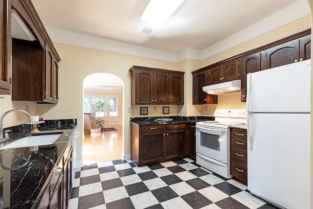 kitchen with dark brown cabinetry, sink, and white appliances