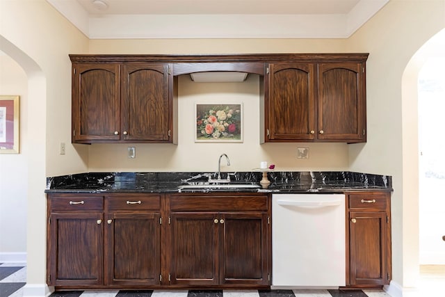 kitchen with white dishwasher, sink, and dark stone countertops