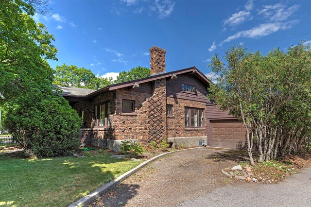 view of property exterior featuring a garage and a lawn