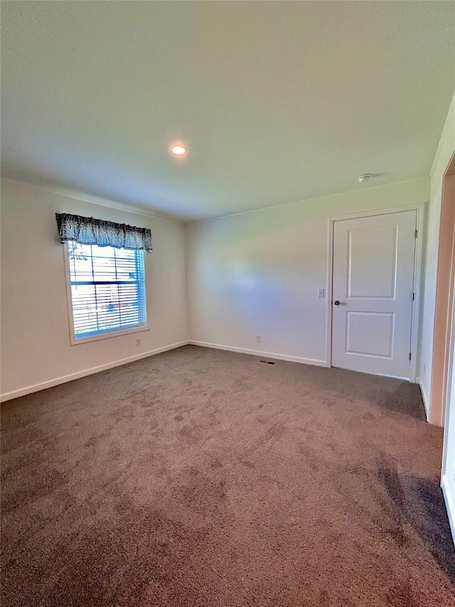 empty room featuring dark colored carpet