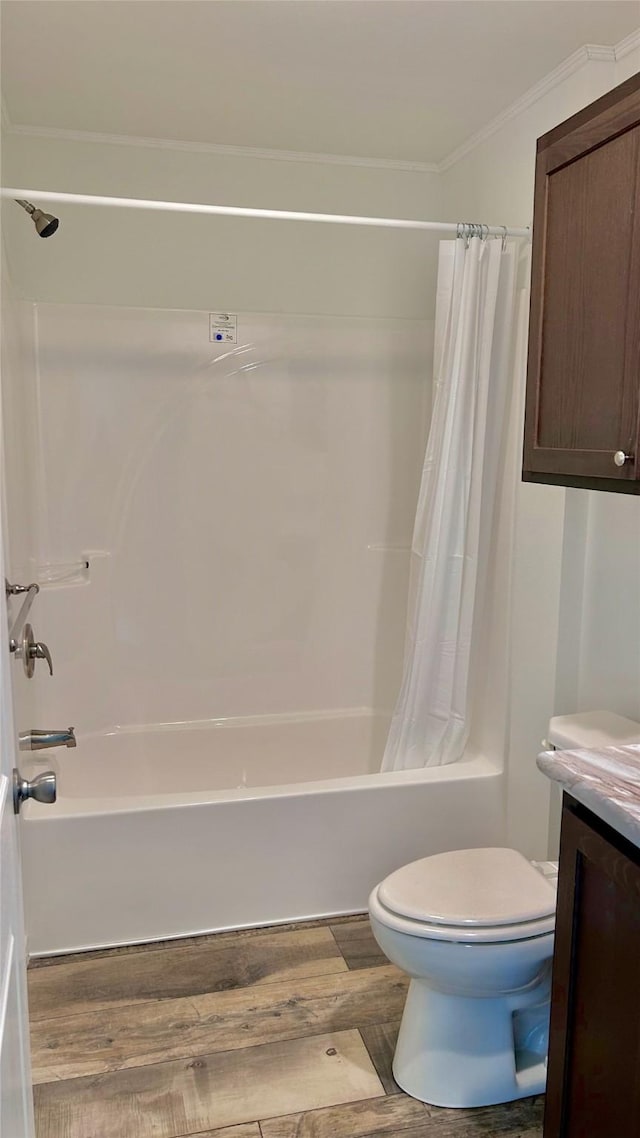 full bathroom with wood-type flooring, vanity, toilet, crown molding, and shower / bath combo with shower curtain