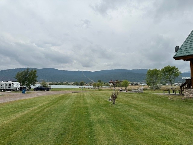 view of property's community with a mountain view and a lawn