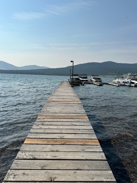 view of dock with a water and mountain view