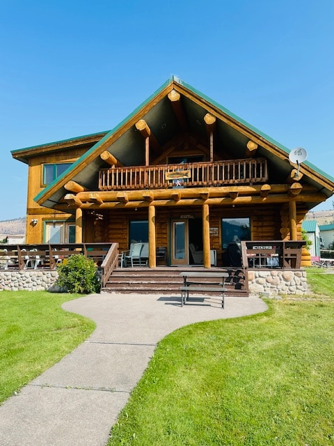 back of property with a lawn and a porch