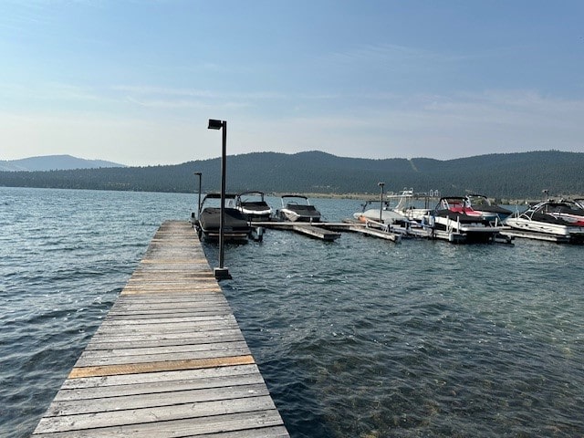 view of dock with a water and mountain view