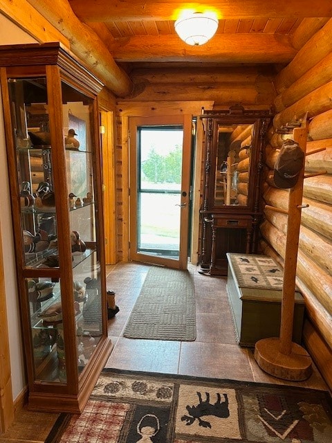 doorway with beam ceiling, wooden ceiling, and rustic walls