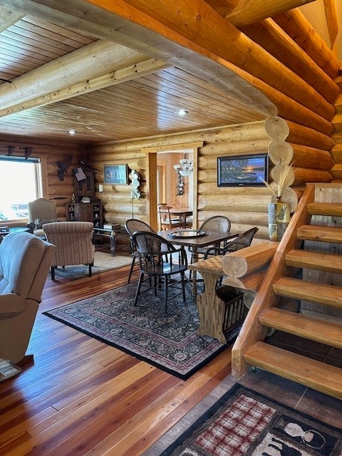 dining space featuring beam ceiling, rustic walls, hardwood / wood-style flooring, and wooden ceiling