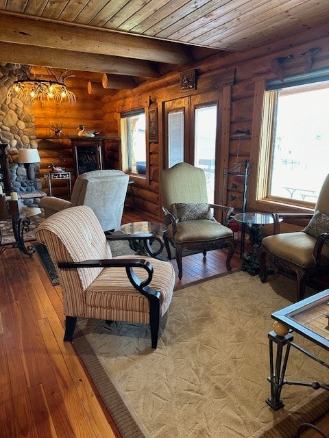 living room featuring light hardwood / wood-style floors, beamed ceiling, wooden ceiling, and rustic walls