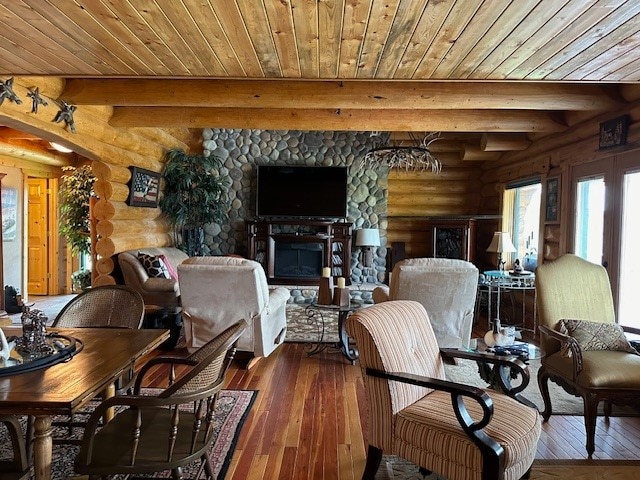 living room featuring a stone fireplace, beamed ceiling, log walls, and dark hardwood / wood-style flooring